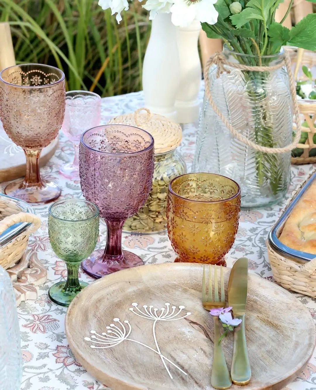Bord dækket med farverige glas, keramik og blomster hos Break